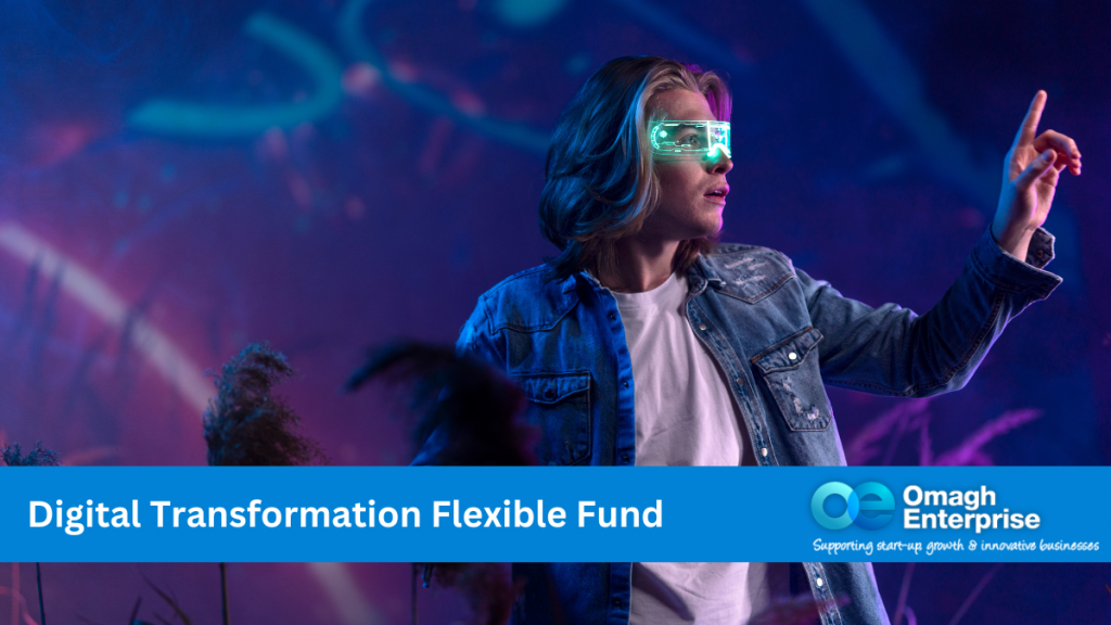 A person, against a blue digital background, is reaching out their hand and touching something off screen. They are wearing a digital blue visor over their face. Blue banner across the bottom. White text "Digital Transformation Flexible Fund" Omagh Enterprise logo within the blue banner