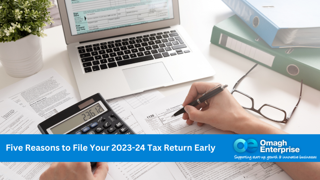 A left hand holding a calculator and right hand filling in a tax form. A pair of glasses sitting on the desk, beside a monitor with tax website opened. Blue banner along the bottom. White text Five Reasons to File Your 2023-24 Tax Return Early Omagh Enterprise logo in banner