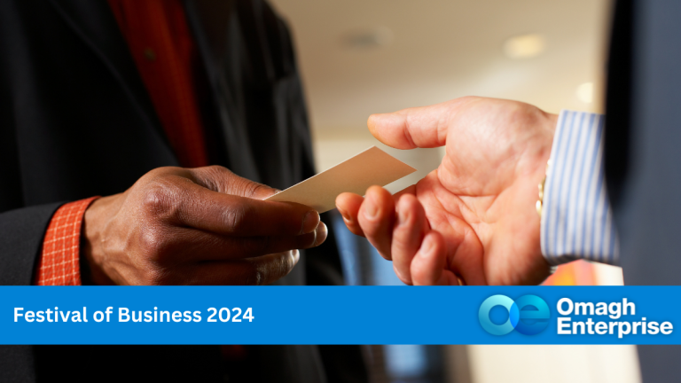 One hand giving another hand a business card at a networking event. Blue banner along the bottom. White text "Festival of Business 2024" Omagh Enterprise logo within the blue banner.