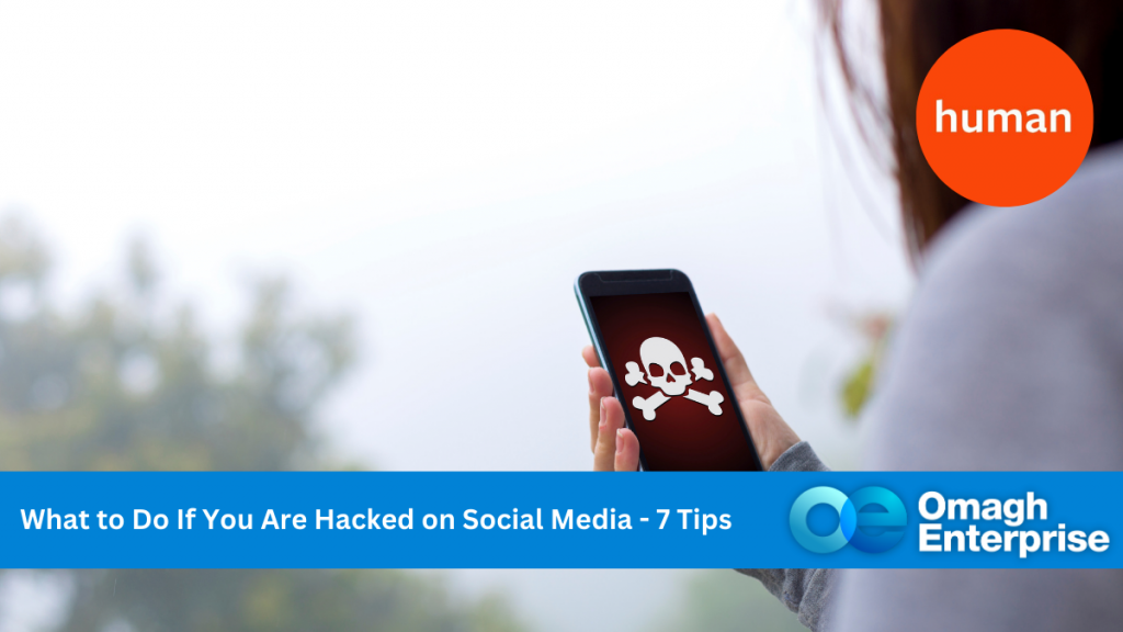 A hand outside holding a mobile phone. On the phone's screen, it the Jolly Roger skull. Blue banner along the bottom, with white text. "What to Do If You Are Hacked on Social Media - 7 Tips" Omagh Enterprise logo within the banner.