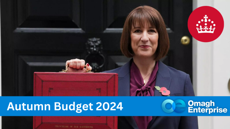 Rachel Reeves stands in front of 10 Downing Street holding the red budget briefcase. She wears a navy suit with a poppy pin on her lapel and has shoulder-length brown hair.